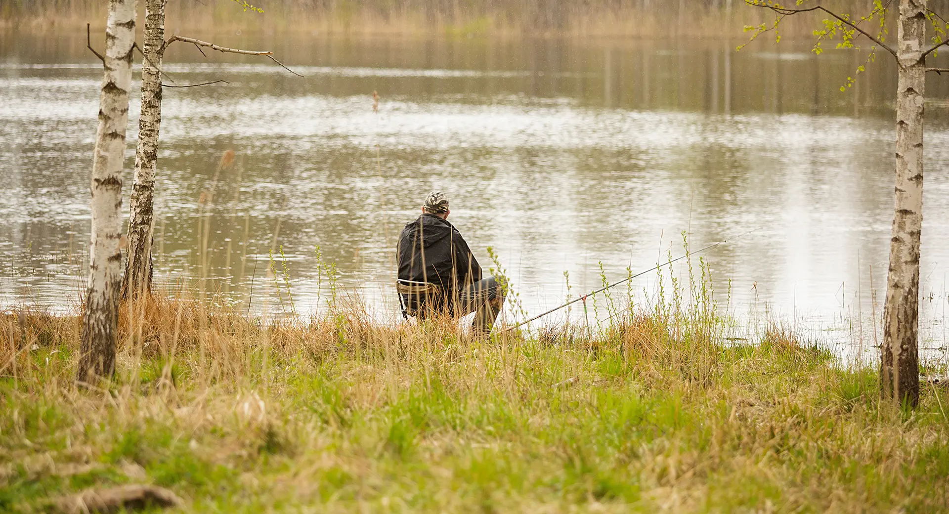 A person fishing by the edge of a lake