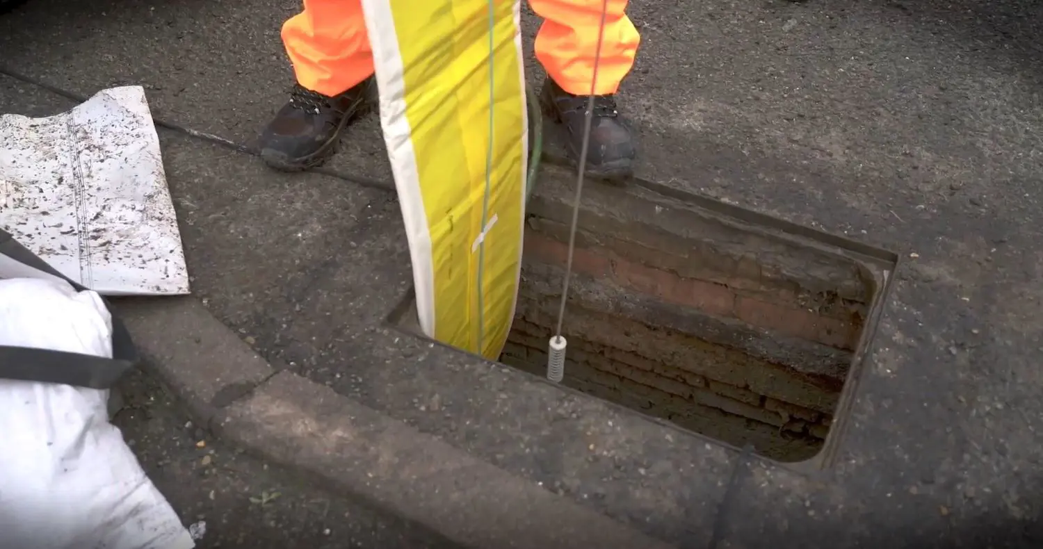 sewer lining being lowered underground