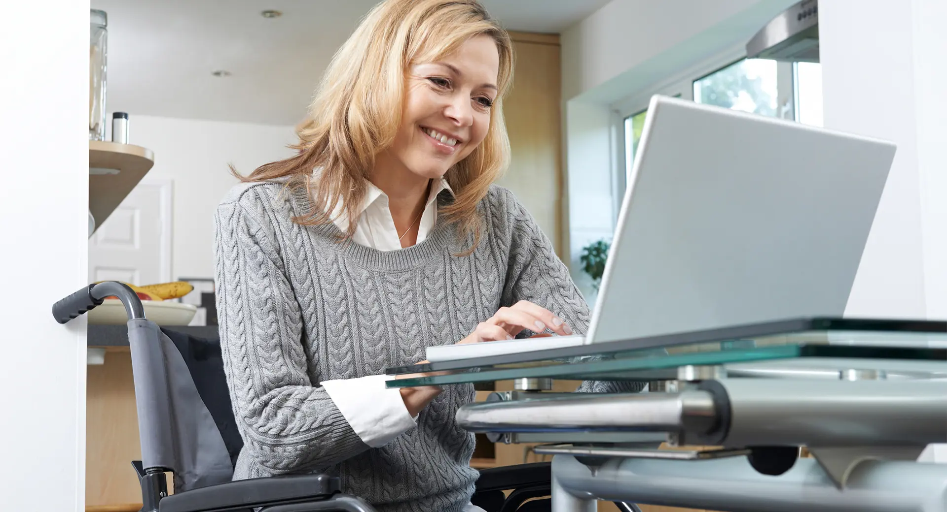 A person looking at a laptop and smiling